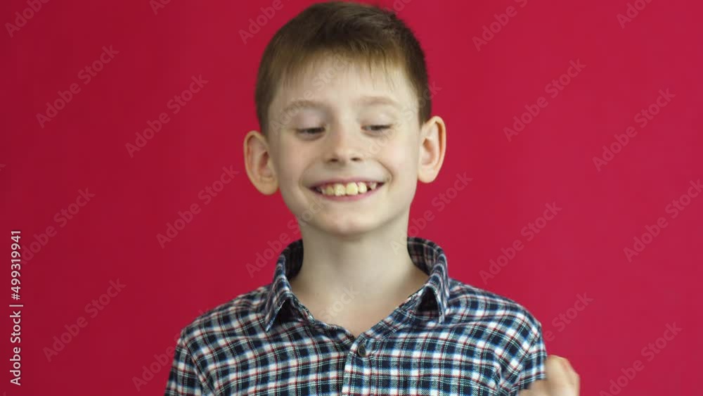 Portrait of a cheerful Caucasian boy 7 years old rejoicing that he removed a sick milk swinging tooth.Studio shooting on a red background. Joyful child pulled out a milk tooth Portrait of a cheerful Caucasian boy 7 years old rejoicing that he removed a sick milk swinging tooth.Studio shooting on a red background. Joyful child pulled out a milk tooth