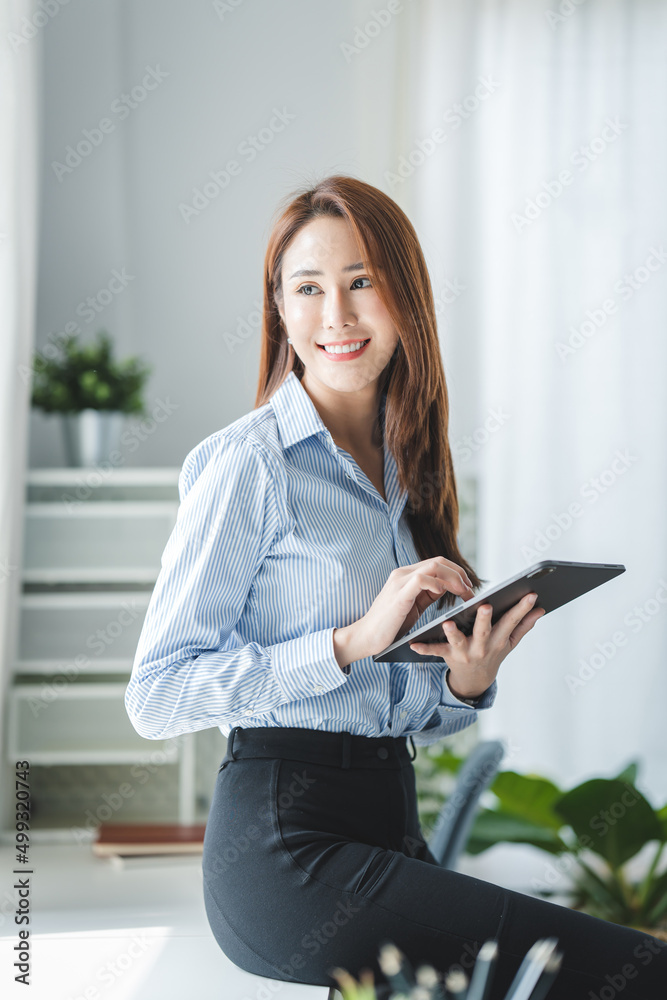 Portrait of a beautiful businesswoman in the office. holding a tablet in hand Portrait of a beautiful businesswoman in the office. holding a tablet in hand