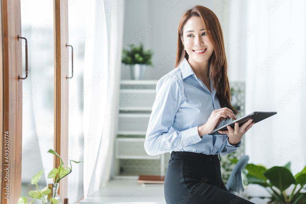 Portrait of a beautiful businesswoman in the office. holding a tablet in hand Portrait of a beautiful businesswoman in the office. holding a tablet in hand