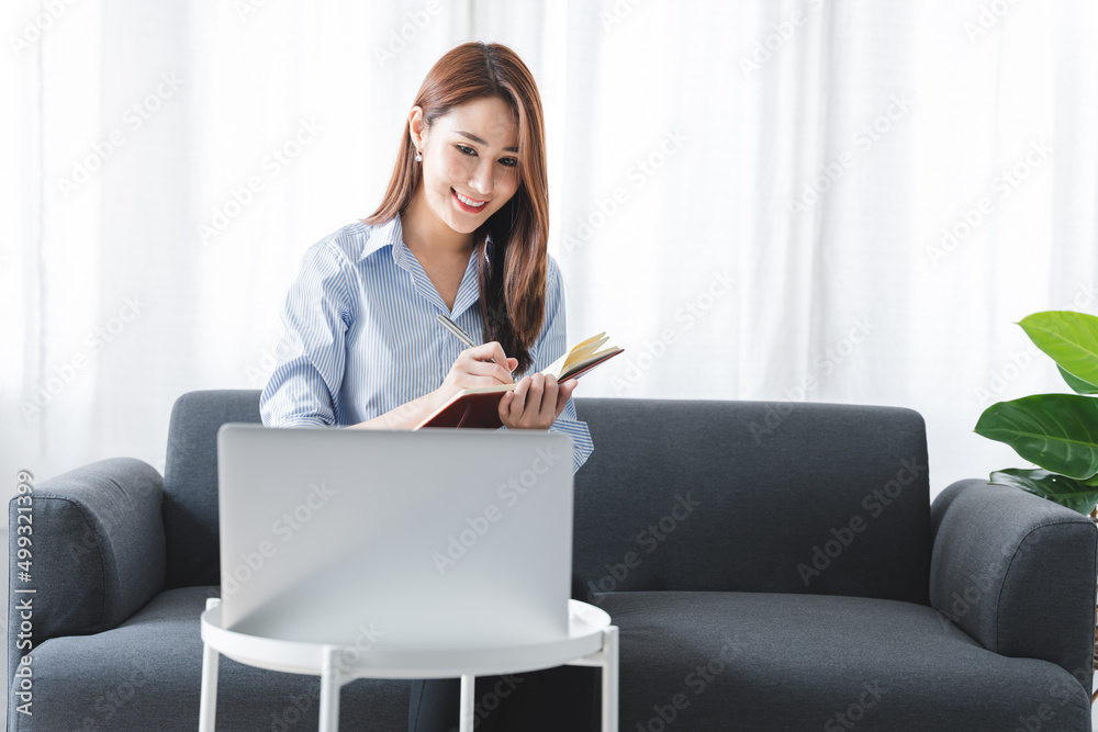 girl sitting on the sofa at home working on the computer. beautiful smile girl sitting on the sofa at home working on the computer. beautiful smile