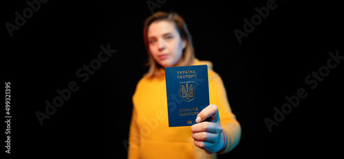 Ukraine national passport. Beautiful ukrainian girl with government passport in her hands on black background.
