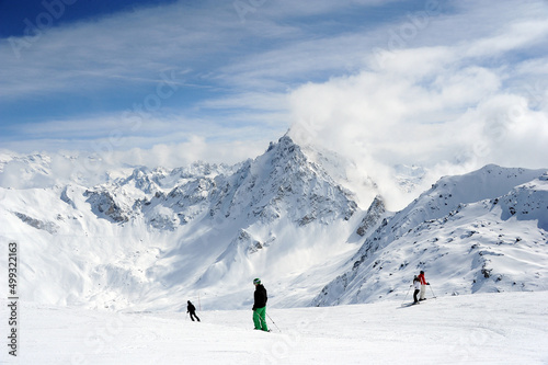 Winter scenery with people skiing at the peak of French alps