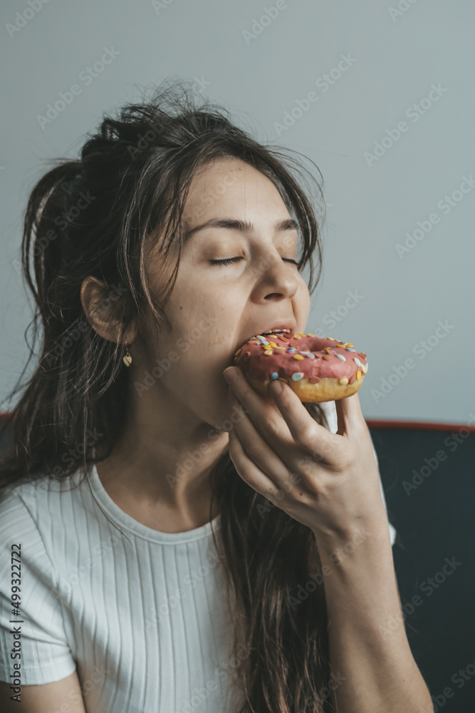 .Close up portrait of pleased pretty girl eating donuts .Close up portrait of pleased pretty girl eating donuts