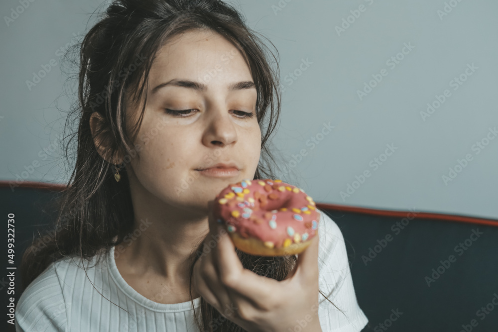 .Close up portrait of pleased pretty girl eating donuts .Close up portrait of pleased pretty girl eating donuts