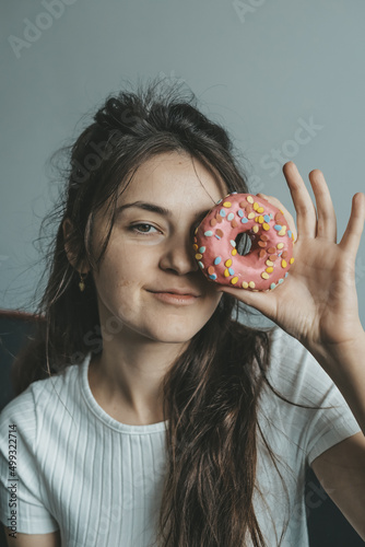 .Close up portrait of pleased pretty girl eating donuts