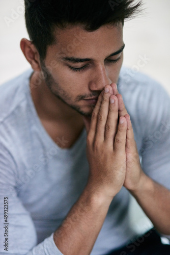 Give us this day our daily bread. Shot of a young man praying.
