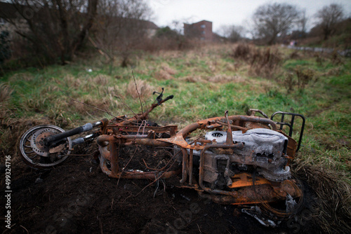 Burnt out motorcycle in fire in field