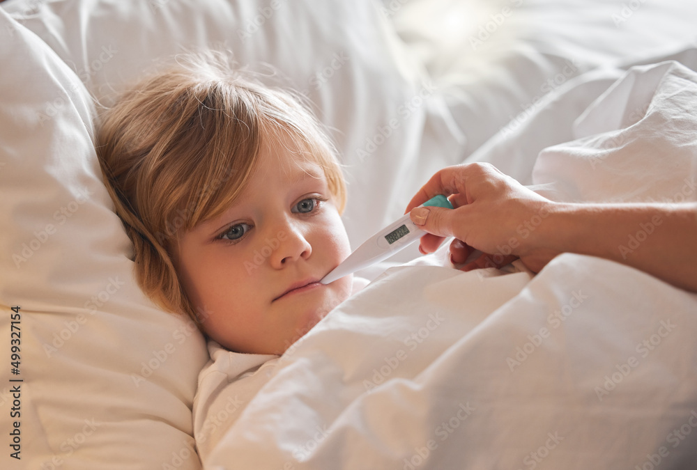 I hope this temperature has come down. Shot of an unrecognisable woman taking a little girls temperature with a thermometer in bed at home.