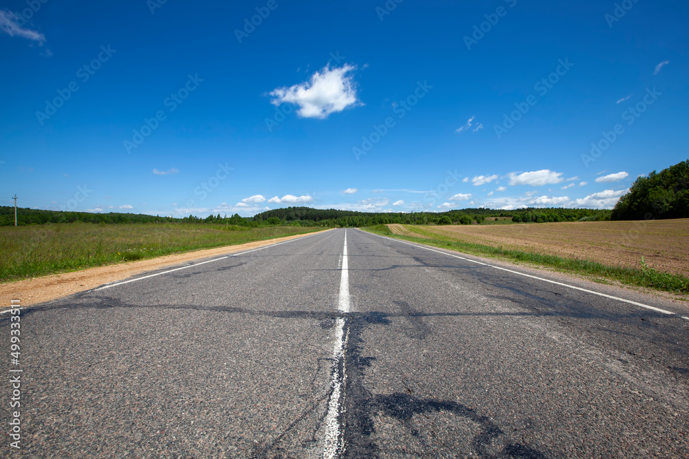 paved highway with blue sky and clouds