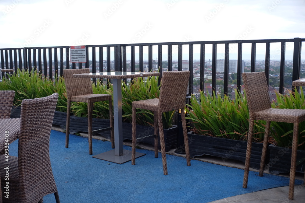 Chairs and tables for hanging out on a roof top hotel with an open air concept.