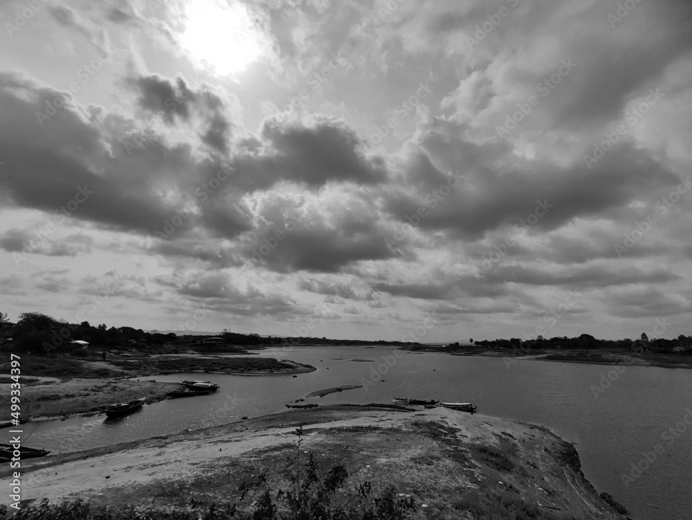 Black and white photo of clouds over the river