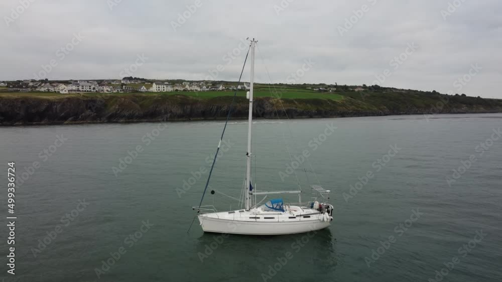 Flying through Cardigan bay, Wales, sailboat in the wind with anchor down. Drone footage through the bay 4K. Flying through Cardigan bay, Wales, sailboat in the wind with anchor down. Drone footage through the bay 4K.