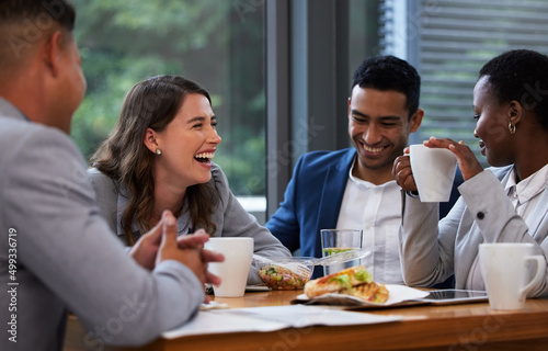 If you can laugh together, you can work together. Shot of a group of colleagues having a meeting and breakfast in a modern office. photo