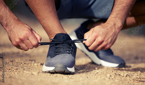 Get ready, its cardio time. Closeup shot of an unrecognisable man tying his shoelaces while exercising outdoors.