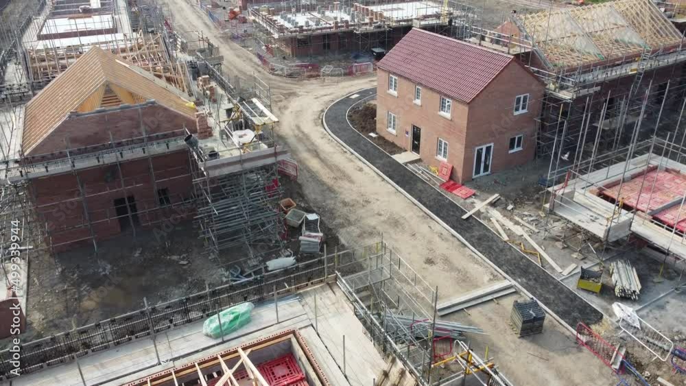 ew UK housing development, showing houses under construction and new builds, in the UK. 4K Arial footage, high quality videography. UK housing project, all stages of construction and development.