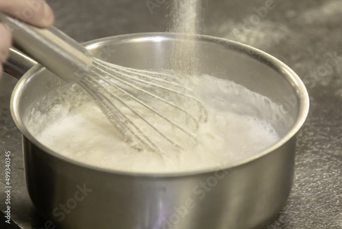 Whisk in pot of melting butter, closeup