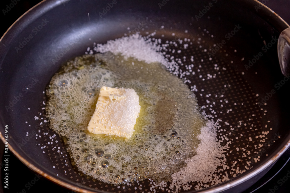 Boiling sugar syrup in metal saucepan with spoon Boiling sugar syrup in metal saucepan with spoon