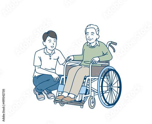 車椅子に乗る年配の男性　介護士　介護スタッフ　シニア　高齢者　息子　親子　笑顔