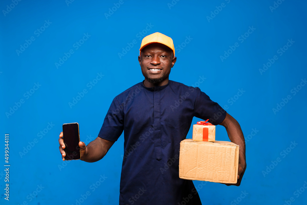 Black Delivery guy holding up mobile phone and a box of present Black Delivery guy holding up mobile phone and a box of present