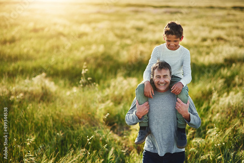 Setting off on an adventure together. Shot of a father carrying his son on his shoulders outdoors.