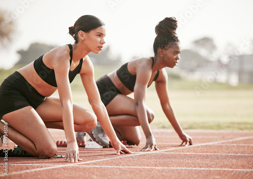 Its a one on one. Cropped shot of two attractive young female athletes starting their race on a track.