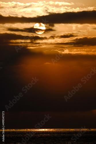 日の出後雲間に透けて見える太陽