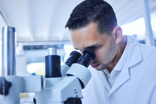 Seeing things the human eye cant. Cropped shot of a handsome young male scientist working with a microscope in his lab.