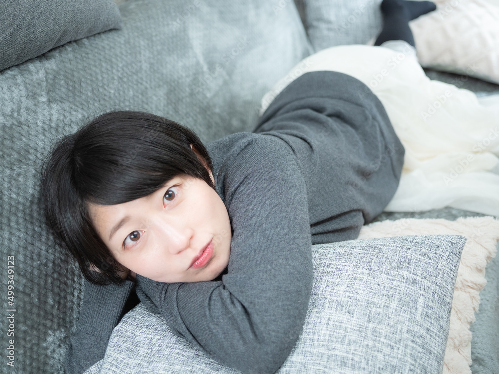 ソファーで寝転ぶ女性 ソファーで寝転ぶ女性