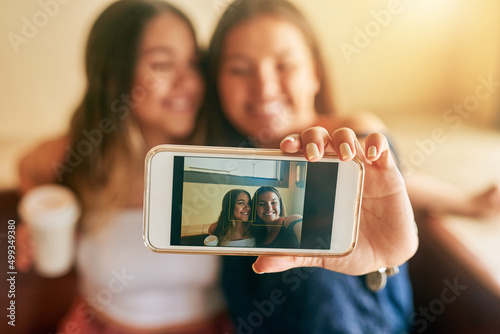 Theres always time for a selfie. Cropped shot of two attractive young women taking selfies in their local cafe.