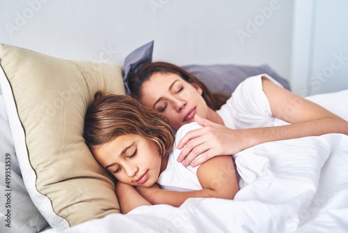 Sound asleep with sweetdreams. Cropped shot of a mother and daughter sleeping together in bed at home.