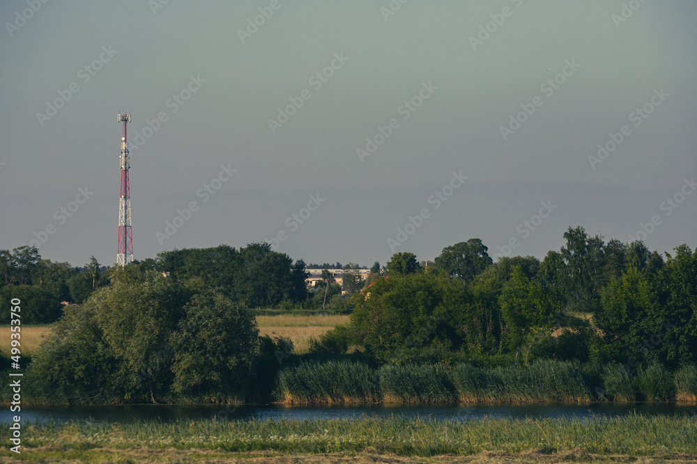landscape with trees, river and communication tower