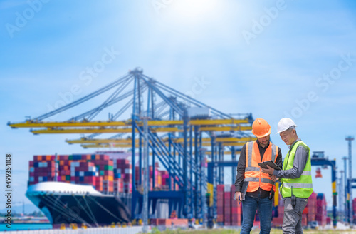 Fotobehang Engineer wearing uniform inspection and see detail on tablet with logistics container dock cargo yard with working crane bridge in shipyard with transport logistic import export background