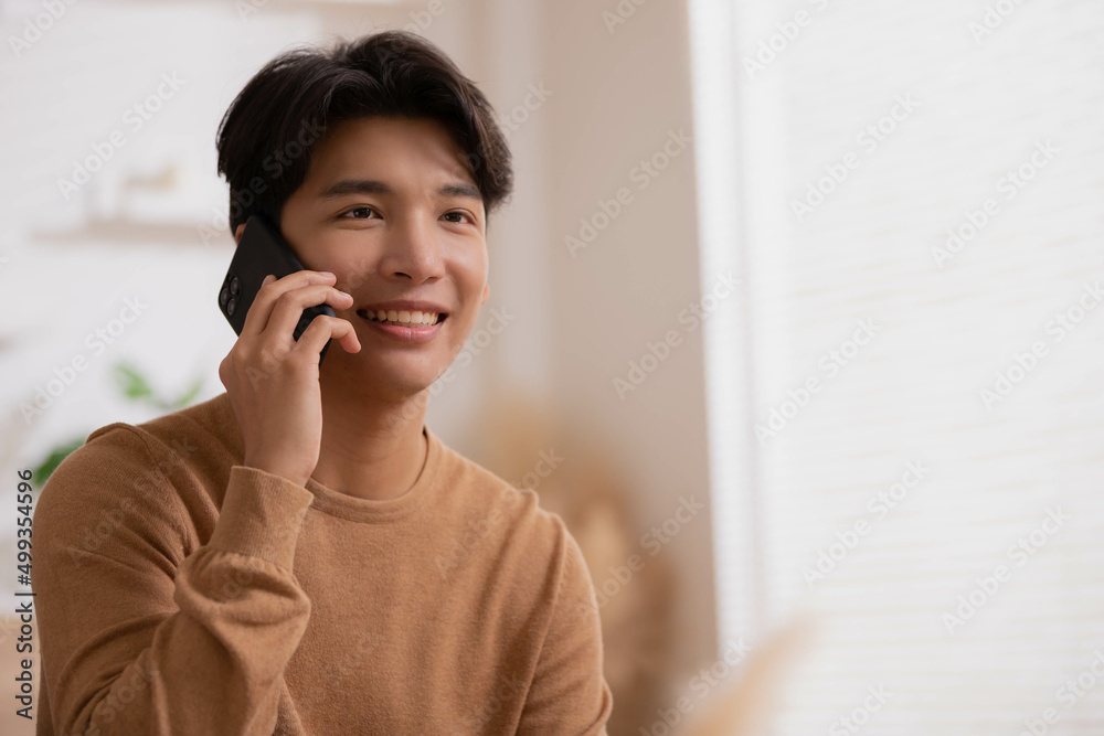 Phone conversation. Confident Asian woman sit on couch talk speak communicate by telephone from home holding device at ear. Phone conversation. Confident Asian woman sit on couch talk speak communicate by telephone from home holding device at ear.
