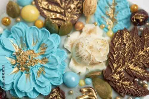 Handmade chocolate bar decorated with flowers and leaves. Close-up