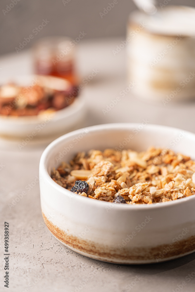 Delicious homemade granola in a bowl on gray background. Breakfast. Healthy food sweet dessert snack. Diet nutrition concept. Vegetarian food. Delicious homemade granola in a bowl on gray background. Breakfast. Healthy food sweet dessert snack. Diet nutrition concept. Vegetarian food.