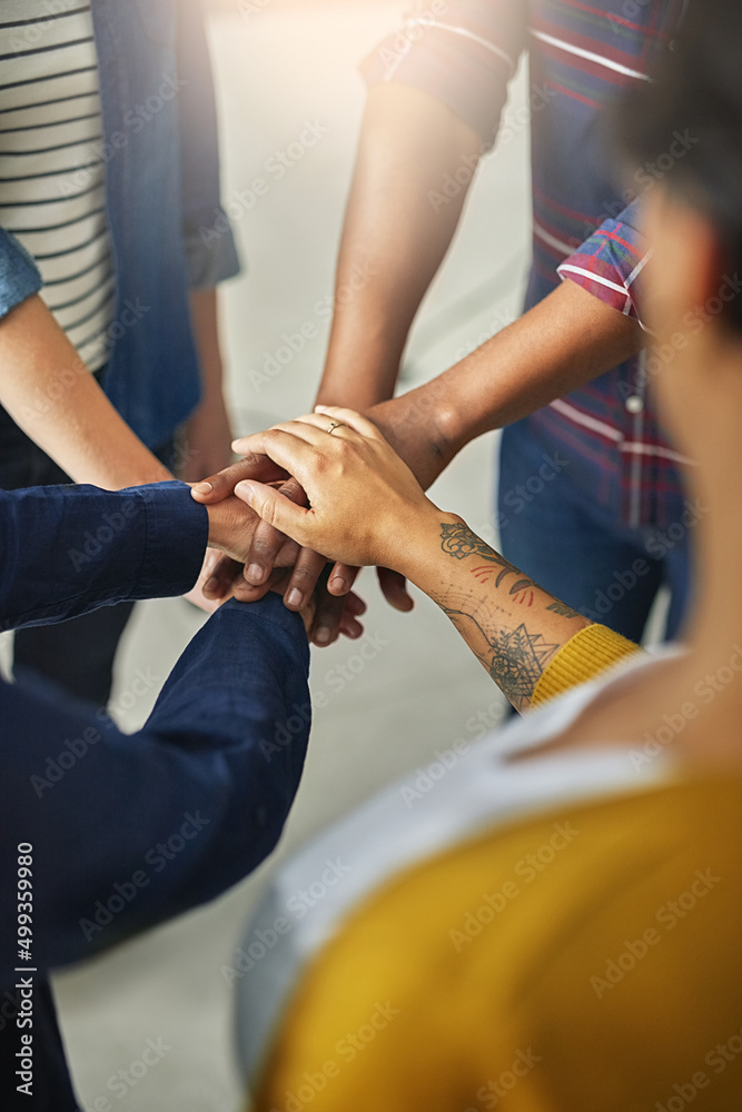 Obraz premium United in the name of creativity. Shot of a team of unidentifiable creatives piling their hands together in the office.