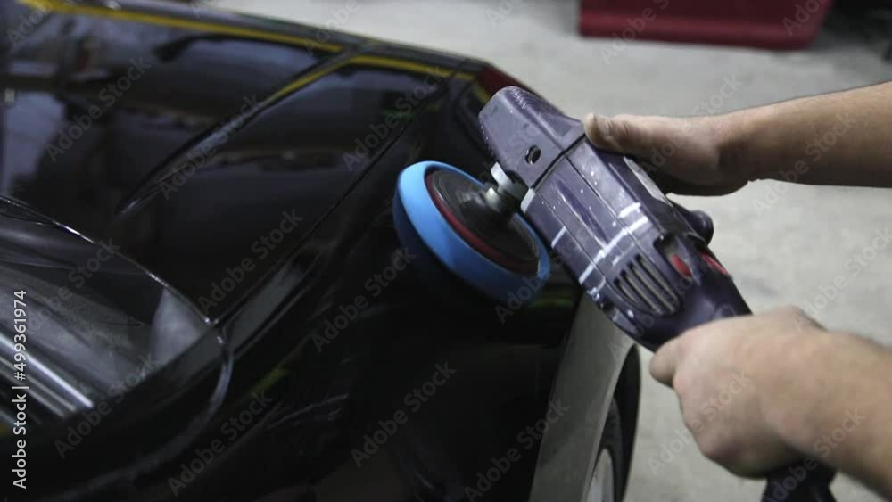 Male hands are polishing the surface of a black car. Car repair service Male hands are polishing the surface of a black car. Car repair service