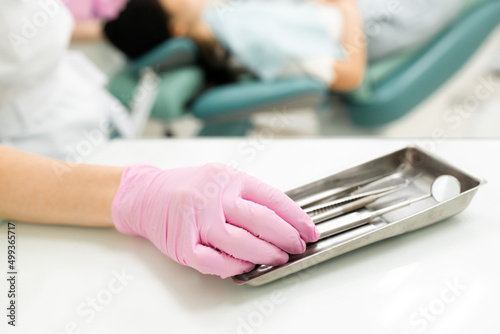 stomatologist hand pink rubber gloves taking professional medical instrument for patient examination