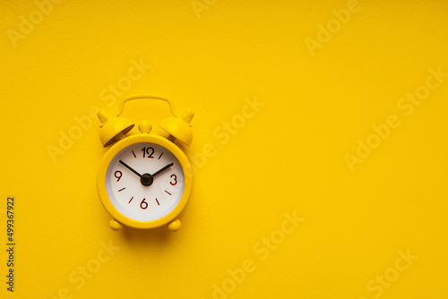 Yellow alarm clock on a yellow background