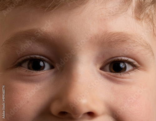 close-up of the boy's brown eyes and blond hair and eyebrows.