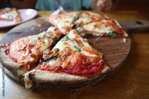 child eating delicious pizza on the wooden plate close-up