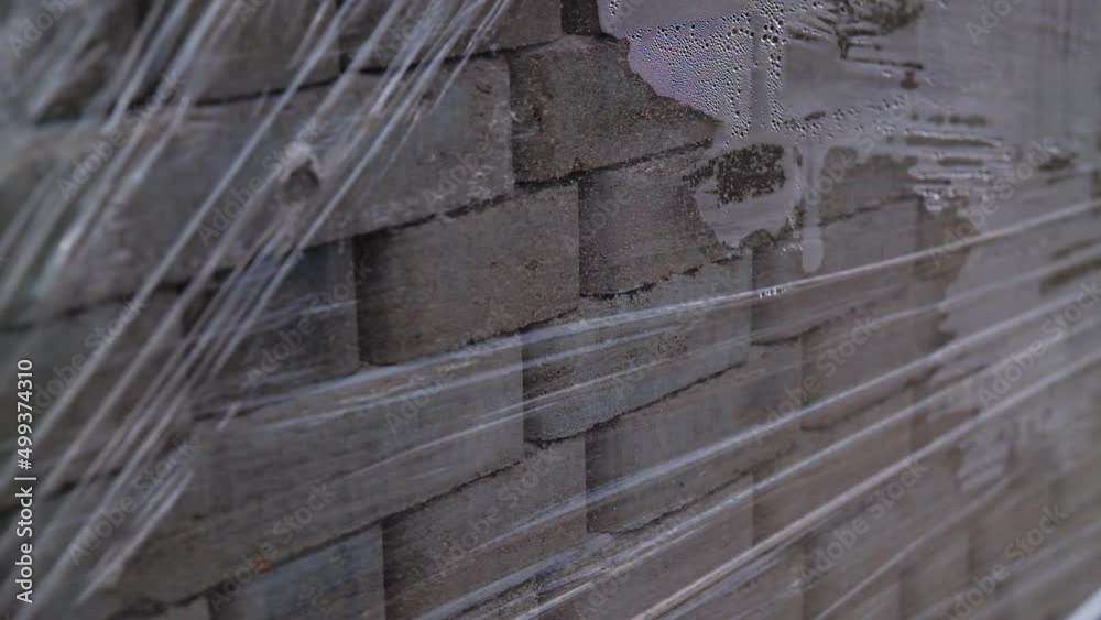 Grey bricks piled in pack and covered with cellophane. Construction materials close up. Grey bricks piled in pack and covered with cellophane. Construction materials close up.