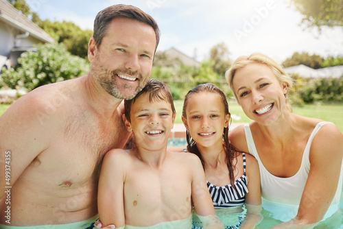 Swimming is an important life skill. Shot of a couple and their two children spending time by the pool.