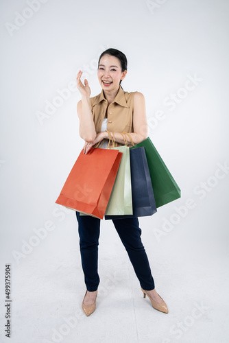 Woman holding paper bags on white background.