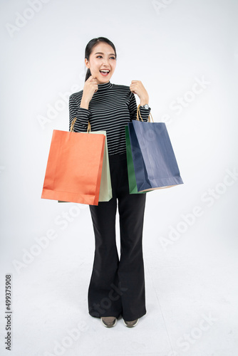 Woman holding paper bags on white background.