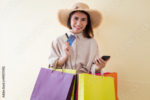 Woman holding paper bags and credit card.