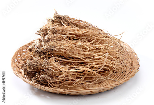 Dried ginseng in a basket is isolated on a white background