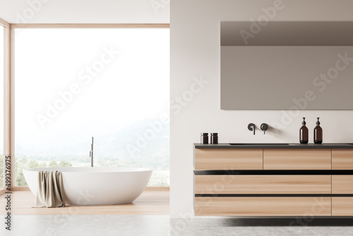 Light bathroom interior with tub, sink and deck, panoramic window