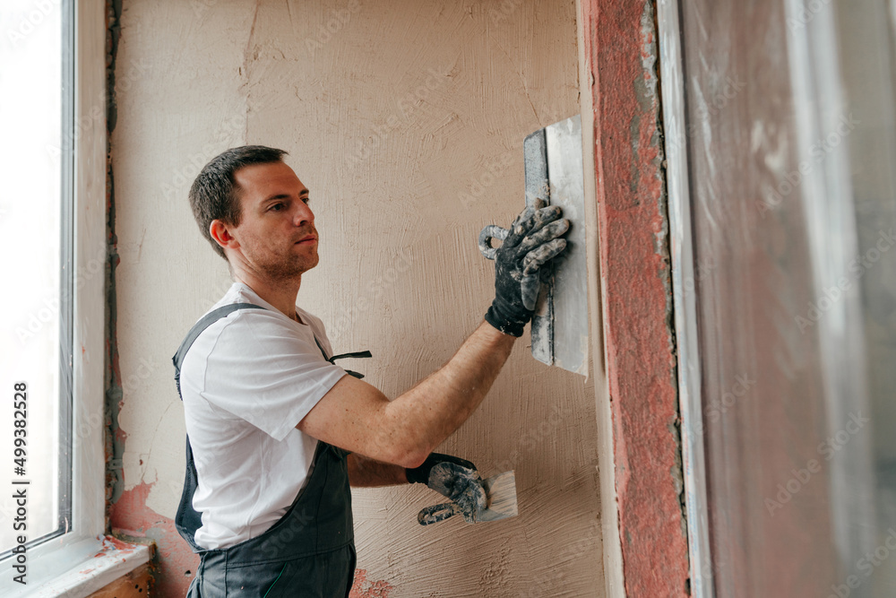 Worker applying putty mortar on the balcony wall Worker applying putty mortar on the balcony wall