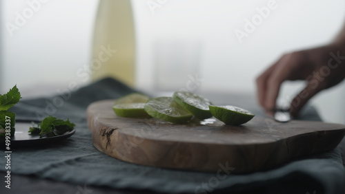 Man slicing lime on olive wood board